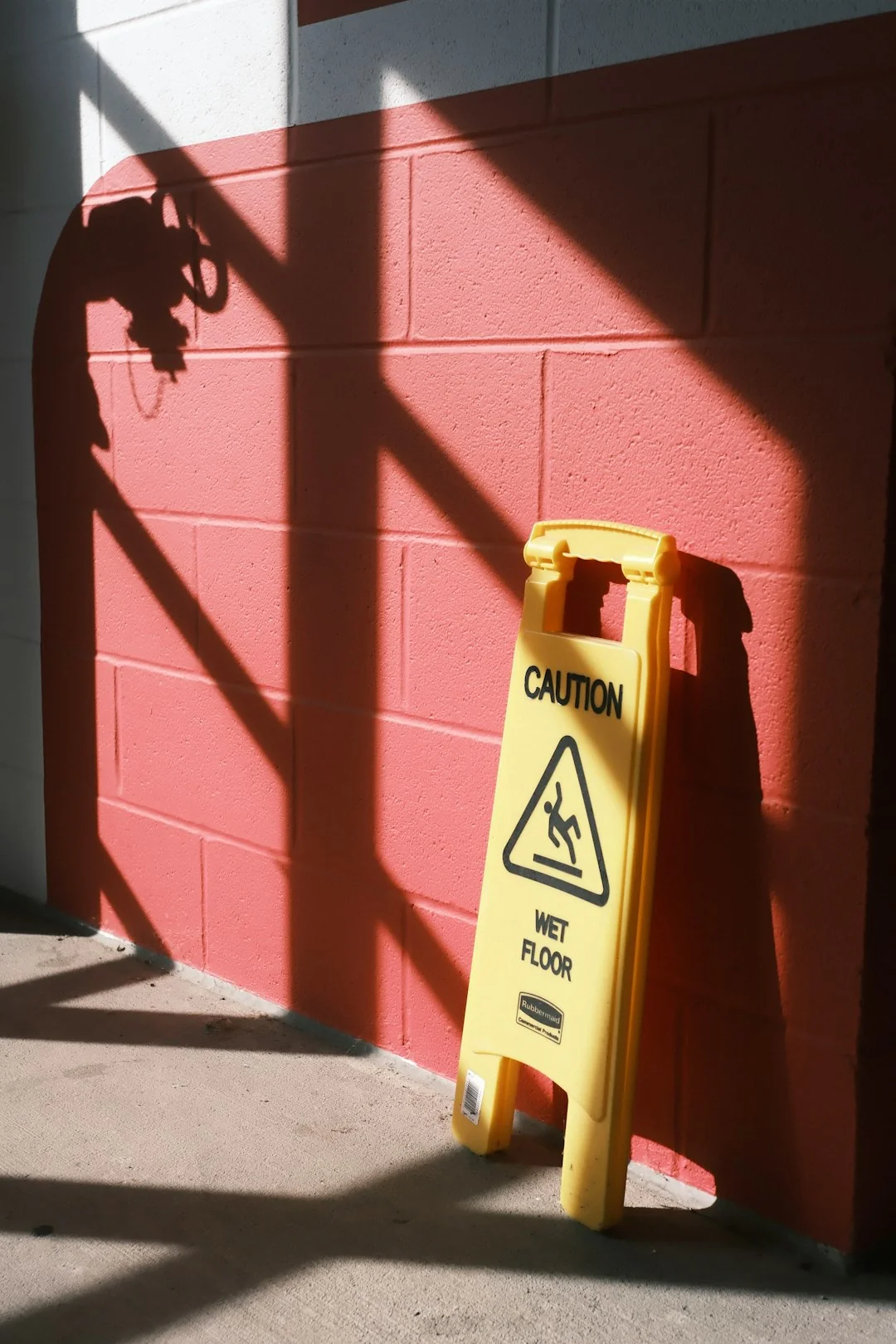 Person in full protective suit cleaning a floor, highlighting safety precautions.